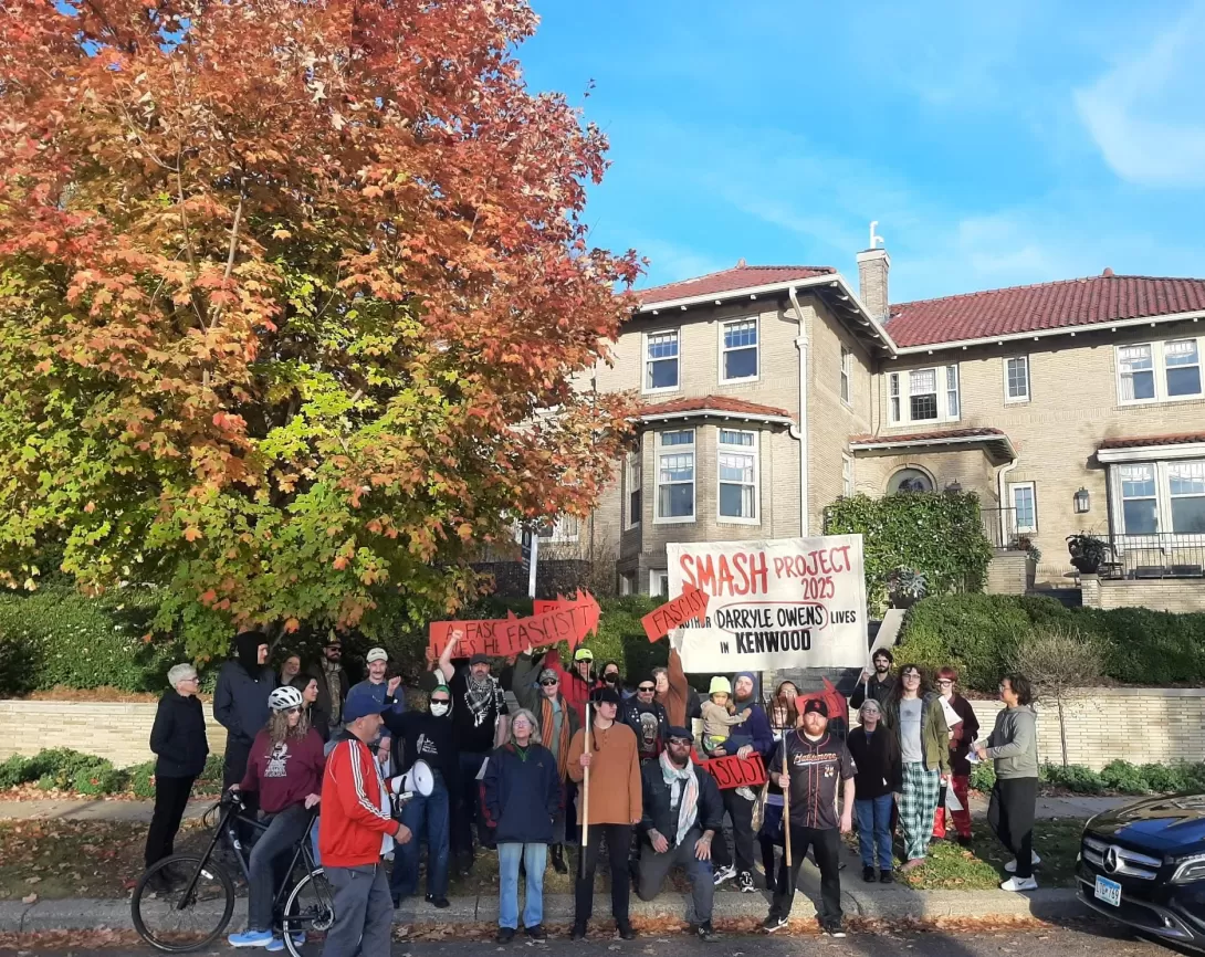 A group of protestors gathered in front of an opulent home
