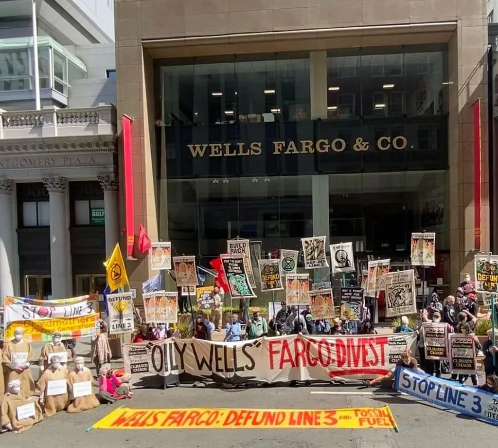 A group of protestors gathers outside of a Wells Fargo location demanding the bank stop investing in fossil fuel projects such as Line 3.